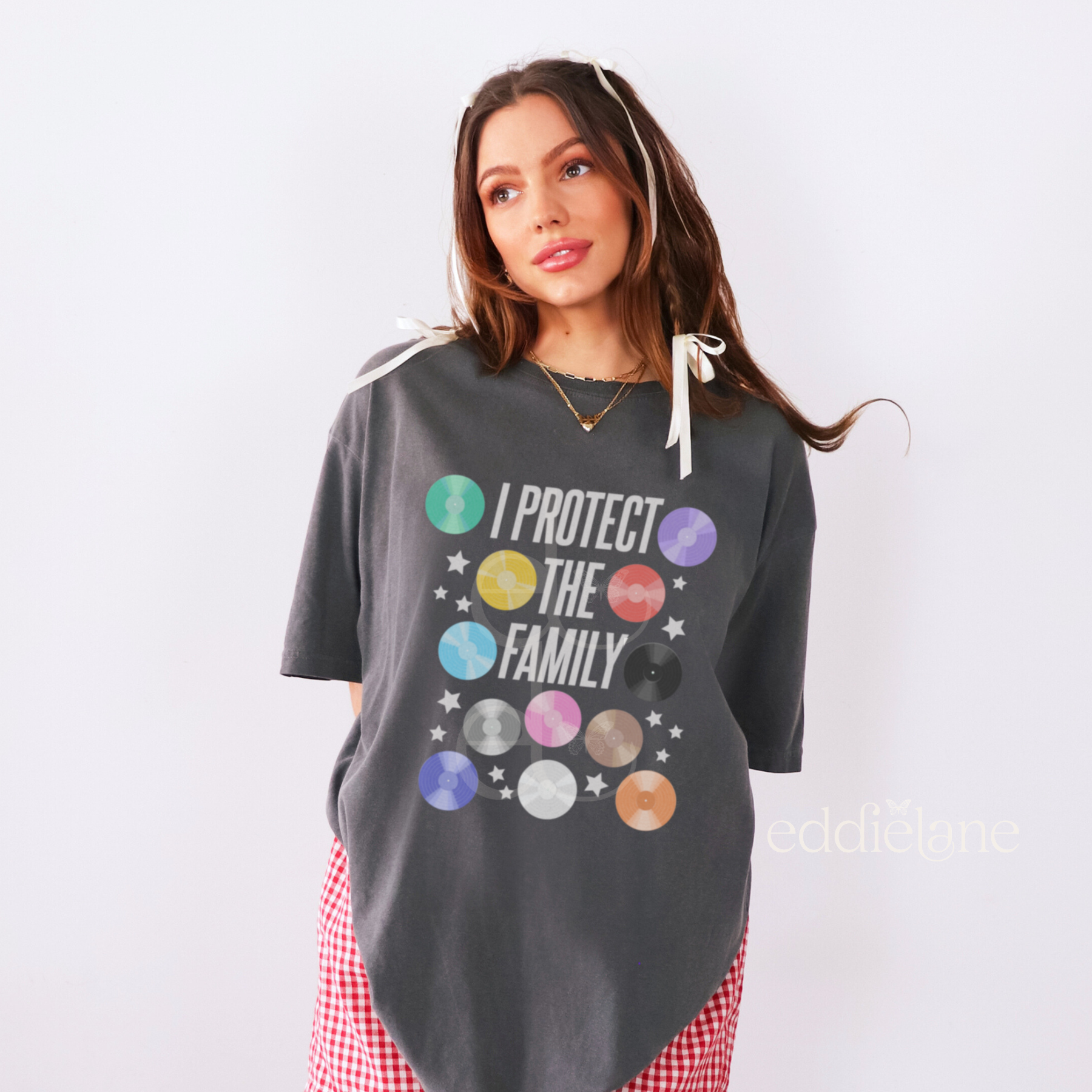 Woman wearing an oversized pepper comfort colors t-shirt with colorful graphic of vintyl records and the words "i protect the family"