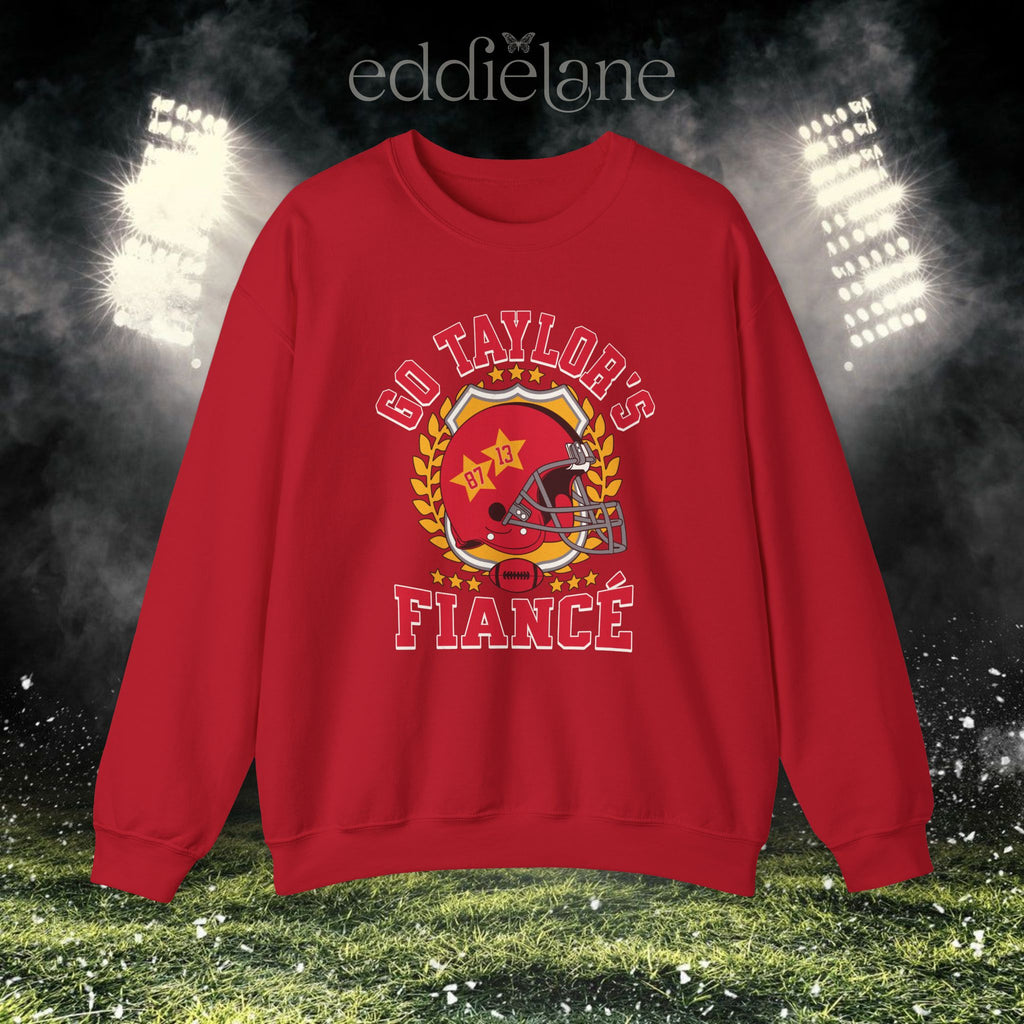 a red crewneck sweatshirt with a vintage football helmet design and text that says "go taylor's fiance"
