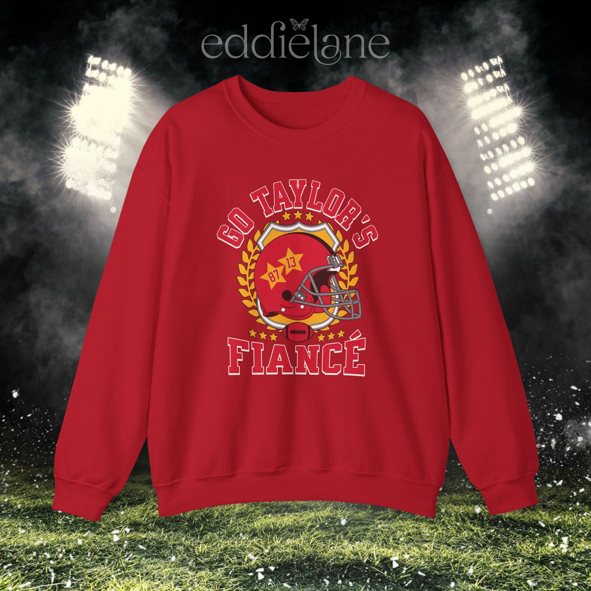 a red crewneck sweatshirt with a vintage football helmet design and text that says "go taylor's fiance"