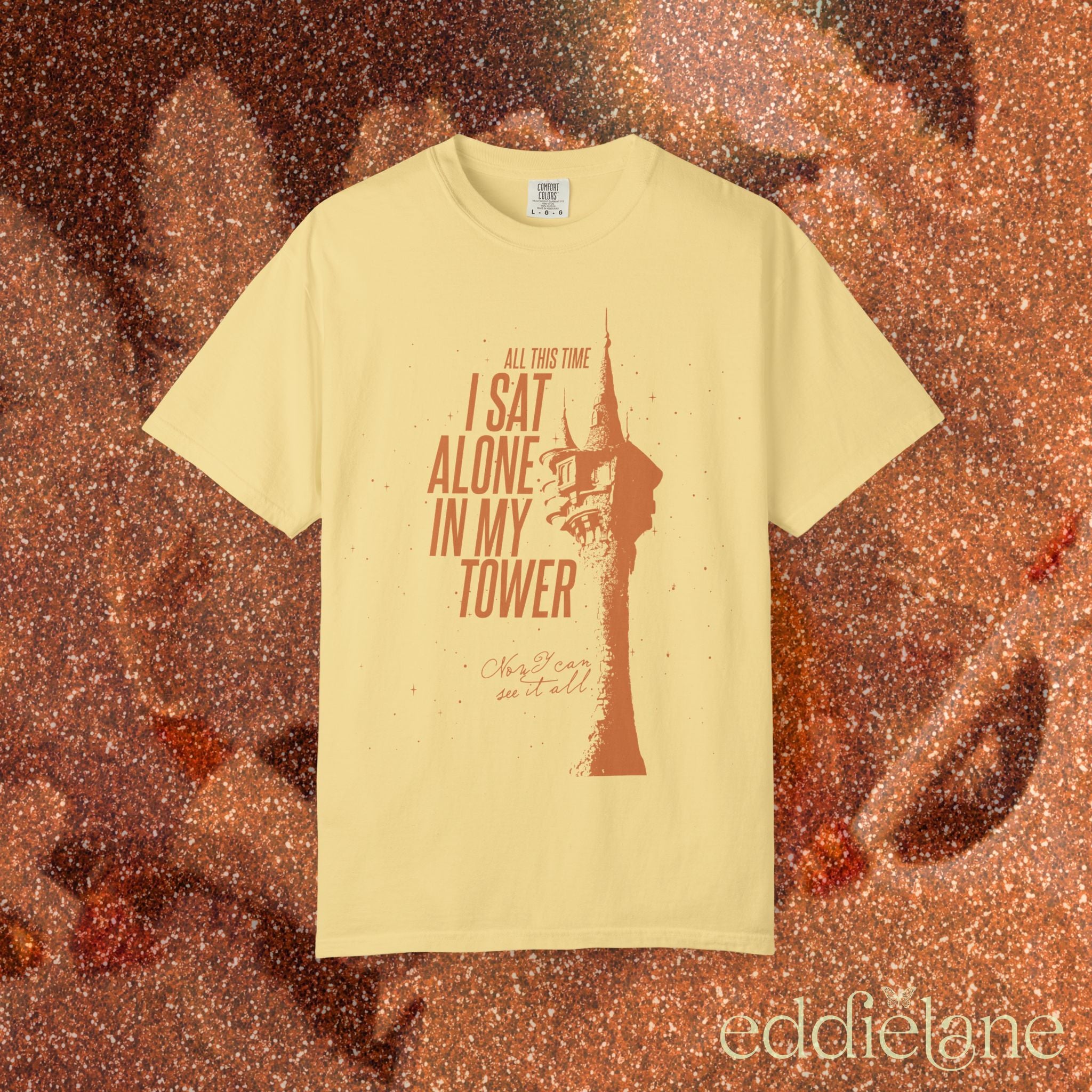 a yellow comfort colors shirt with a graphic of a tower and the words "all this time i sat alone in my tower"