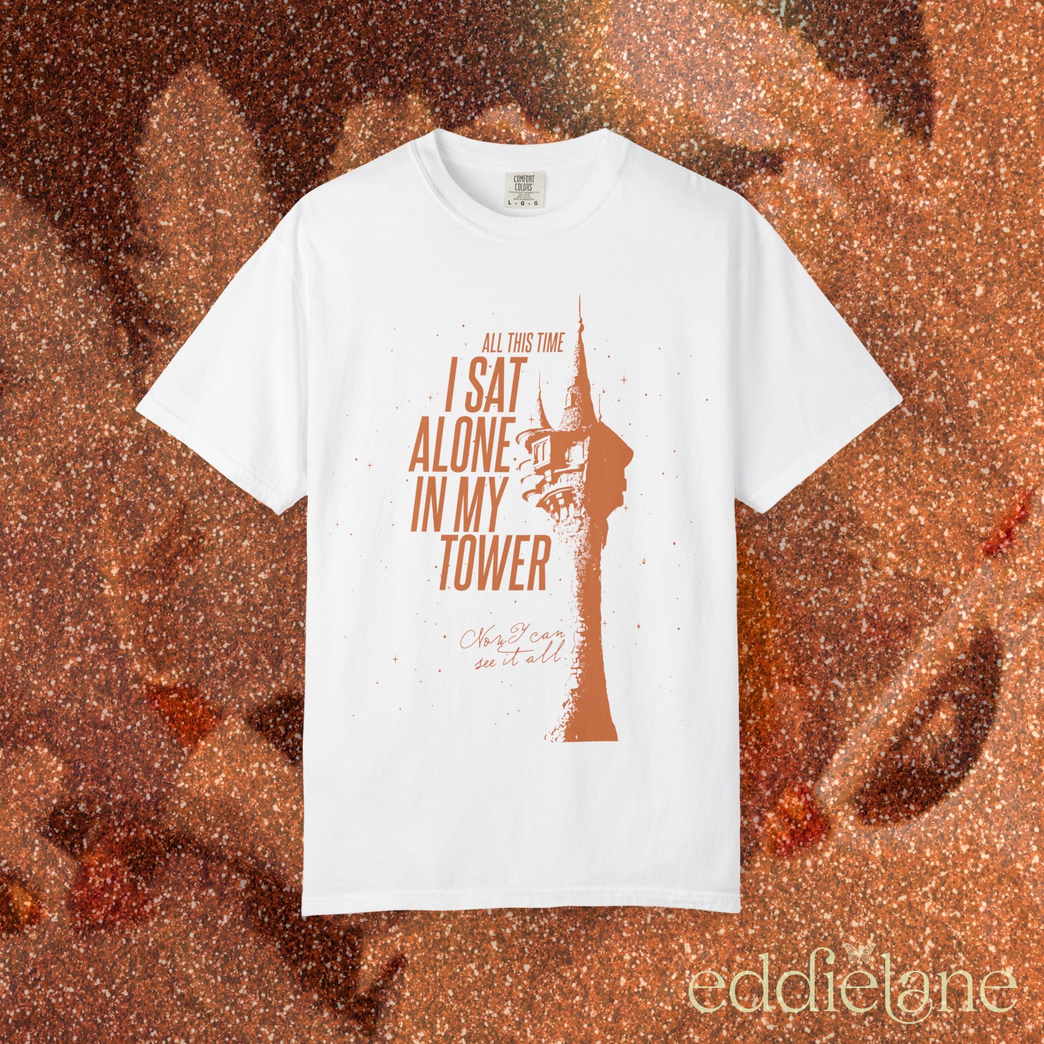 a white comfort colors shirt with a graphic of a tower and the words "all this time i sat alone in my tower"