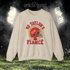 a sand crewneck sweatshirt with a vintage football helmet design and text that says "go taylor's fiance"