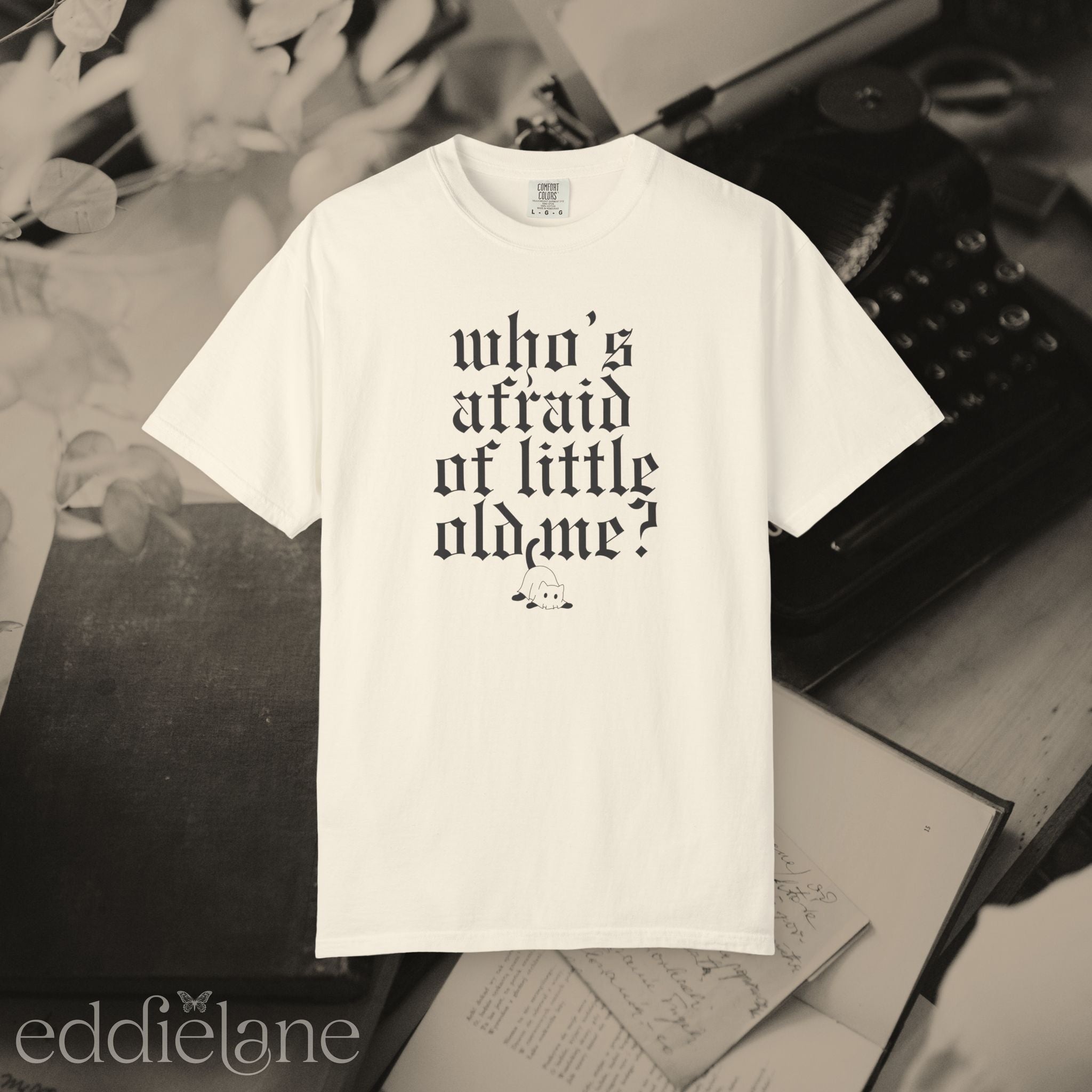 an ivory comfort colors t-shirt that says "who's afraid of little old me" with a graphic of a cat wearing a ghost costume