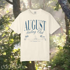 A minimalistic white graphic tee that says 'August Sailing Club' with a sketch design of sailboats on a beach. 