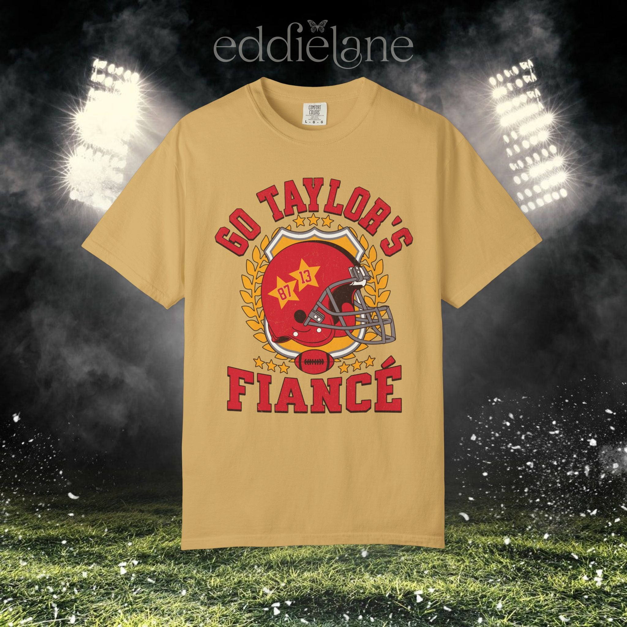 a gold t-shirt with a vintage football helmet design and text that says "go taylor's fiance"