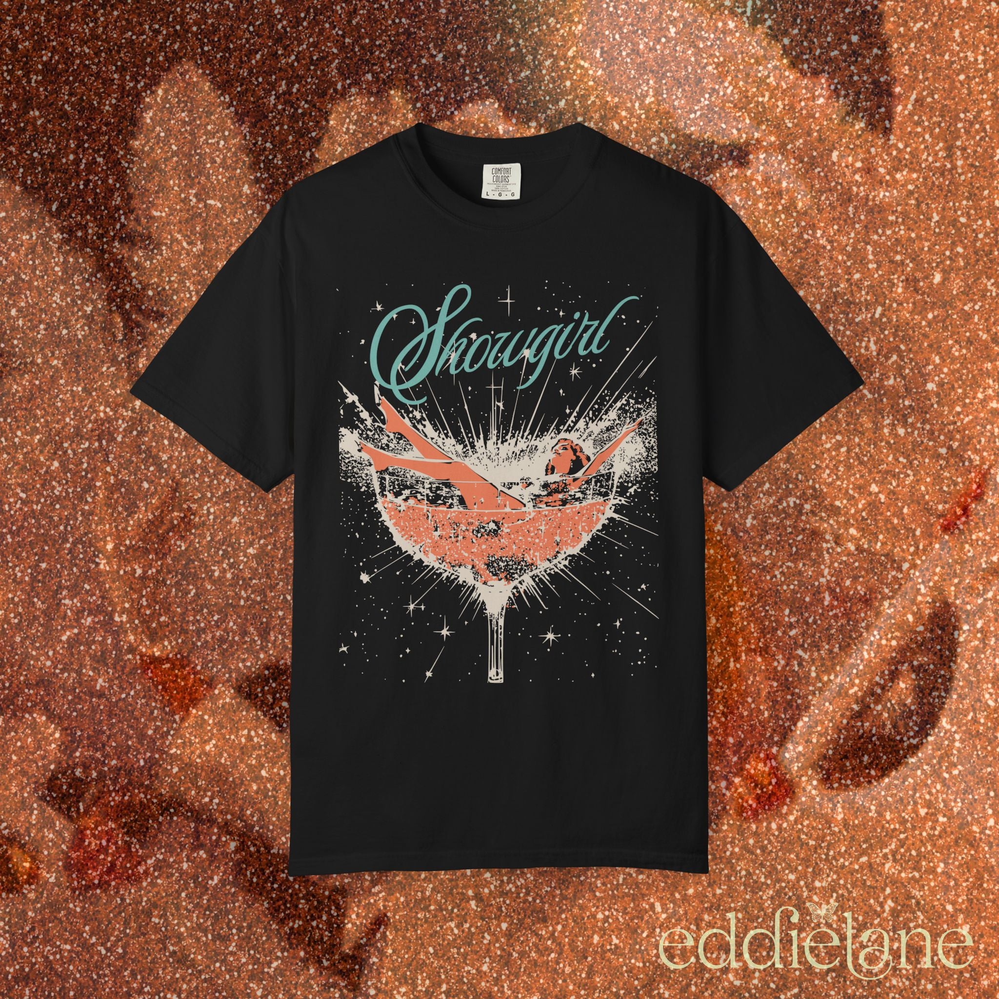 a black t-shirt featuring a graphic of a woman in a champagne glass surrounded by sparkles