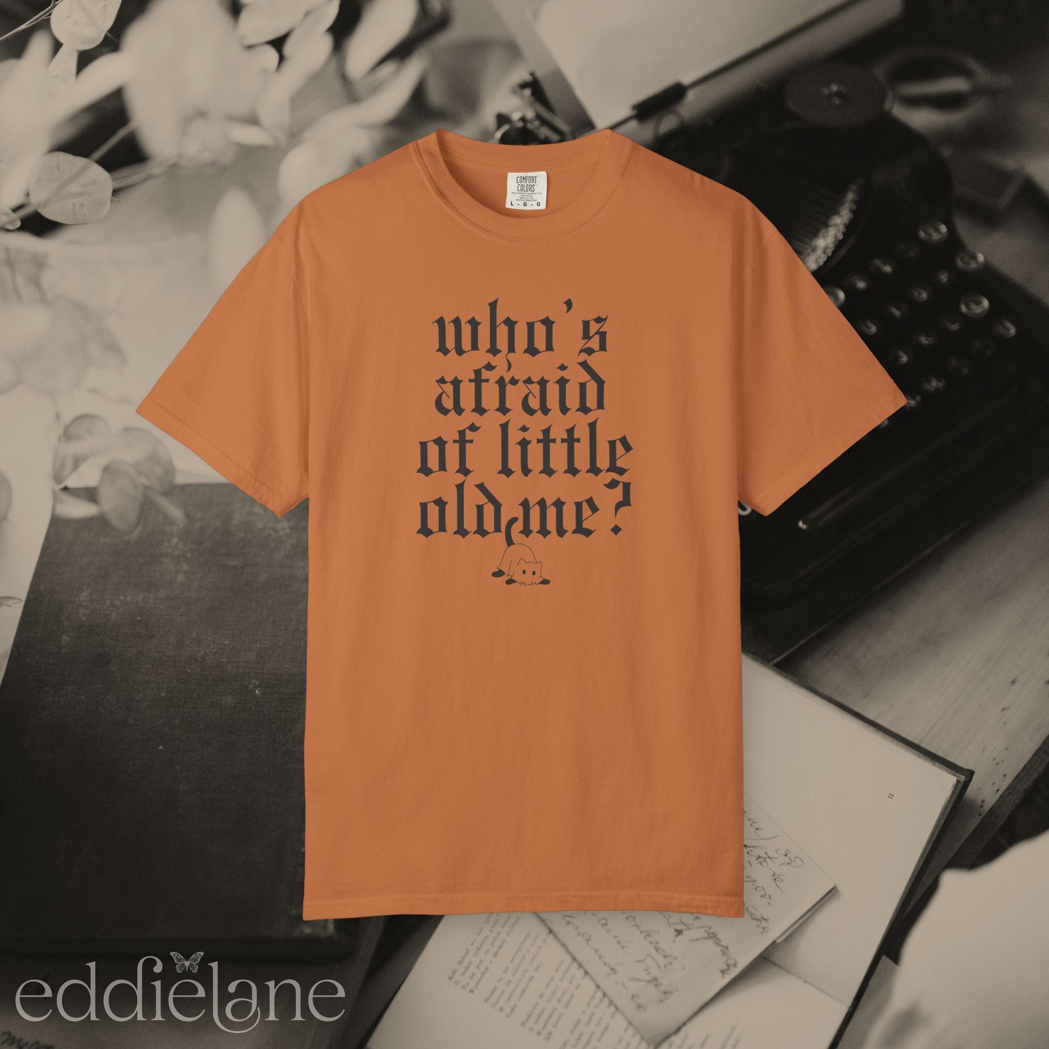 an orange comfort colors t-shirt that says "who's afraid of little old me" with a graphic of a cat wearing a ghost costume