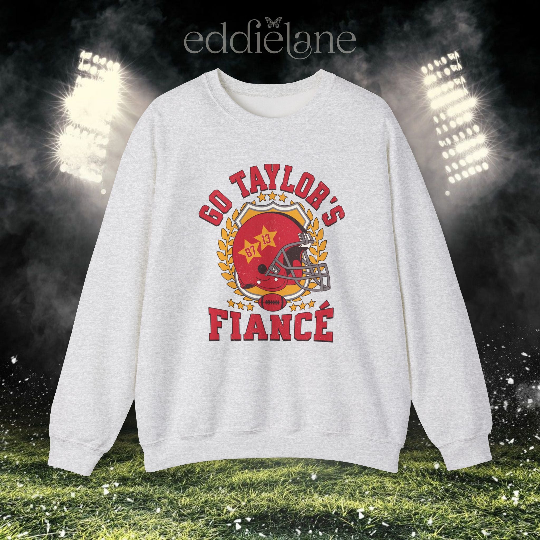 an ash gray crewneck sweatshirt with a vintage football helmet design and text that says "go taylor's fiance"