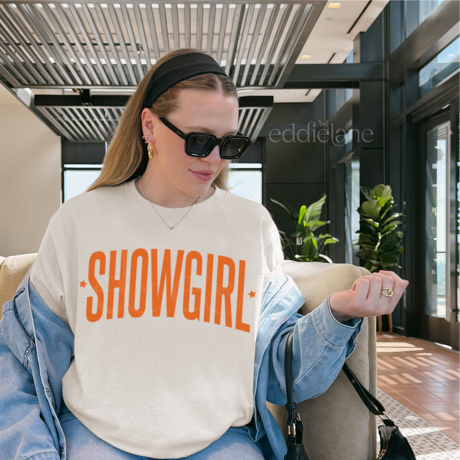 woman wearing an ivory comfort colors graphic tee that says 'SHOWGIRL'

ivory showgirl title tee