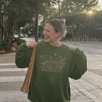 Woman wearing a military green crewneck sweatshirt that says 'it's Actually Romantic' 