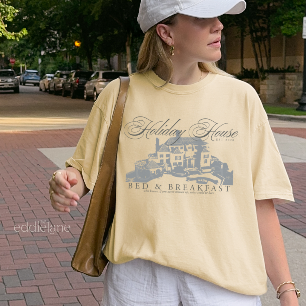 Girl wearing a yellow graphic t-shirt with 'Holiday House Bed & Breakfast' design, banana comfort colors shirt