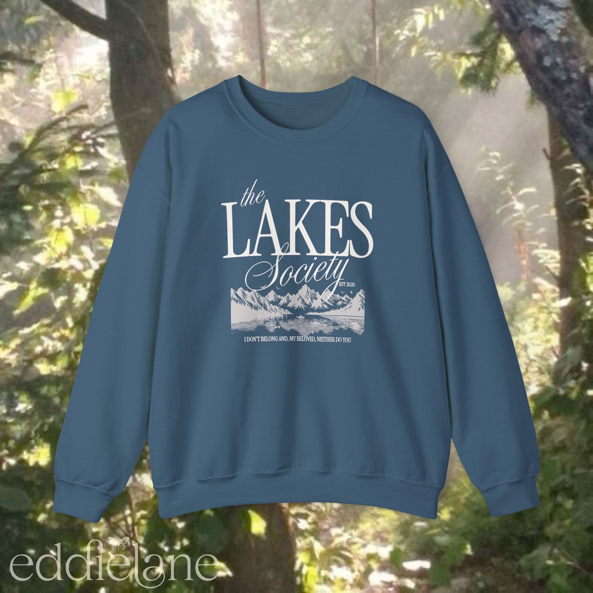 blue sweatshirt with 'The Lakes Society' design and a silhouette of a lake surrounded by mountains, inspired by the lakes by taylor swift from folklore.
blue the lakes sweatshirt 