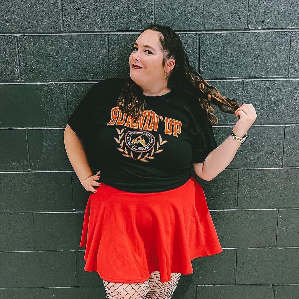 Woman wearing a black collegiate-style t-shirt that says "burnin up" 
