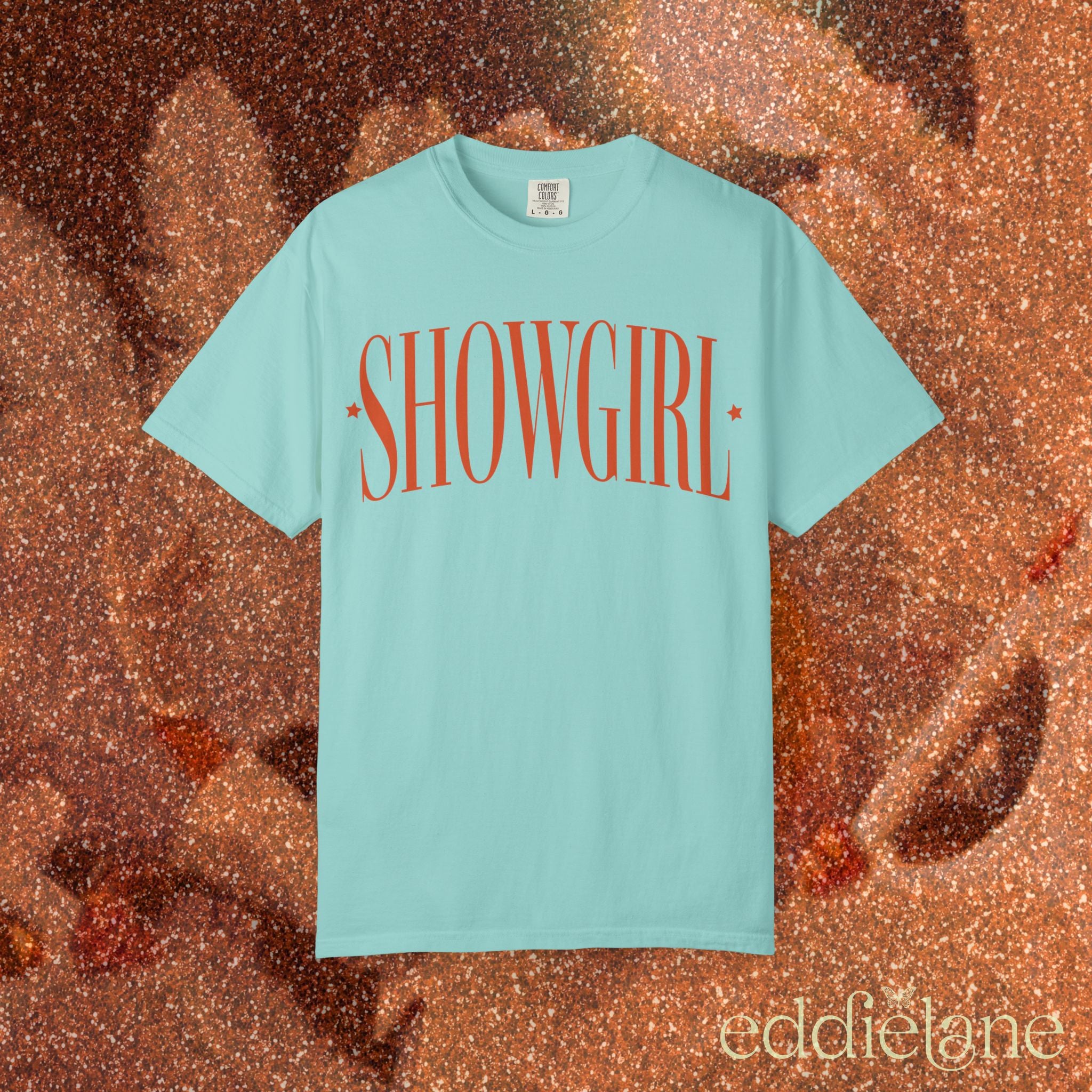 a chalky mint green comfort colors graphic tee that says 'SHOWGIRL' with two small stars

chalky mint green showgirl title tee