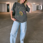 Person wearing a gray graphic tee with a floral design that says 'Charlie's Garden' t-shirt with floral design,