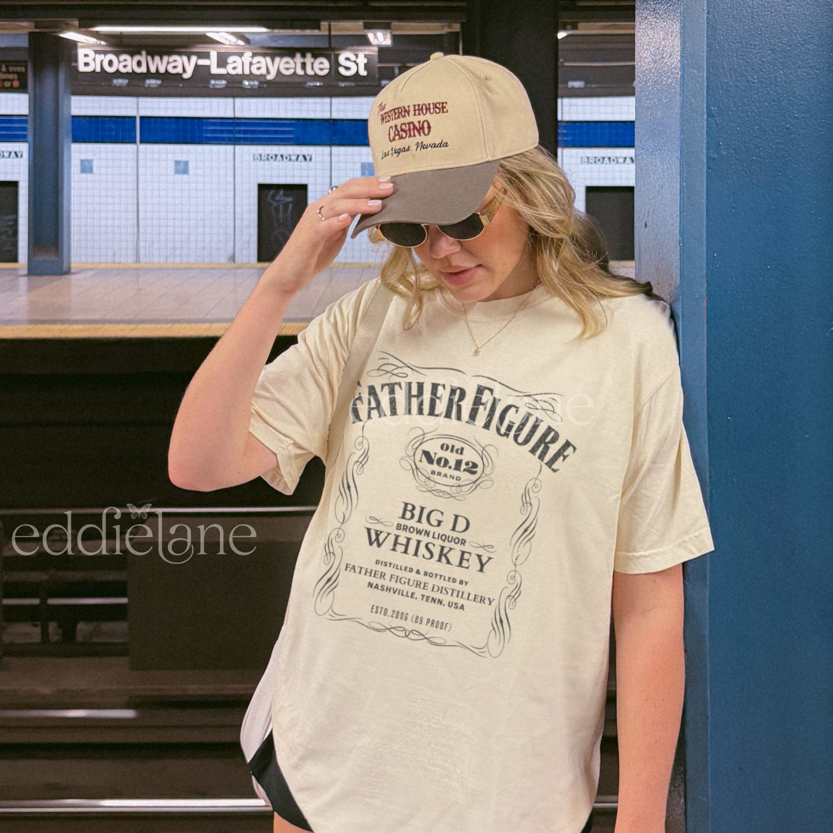 Woman wearing a 'Father Figure Whiskey' graphic t-shirt 