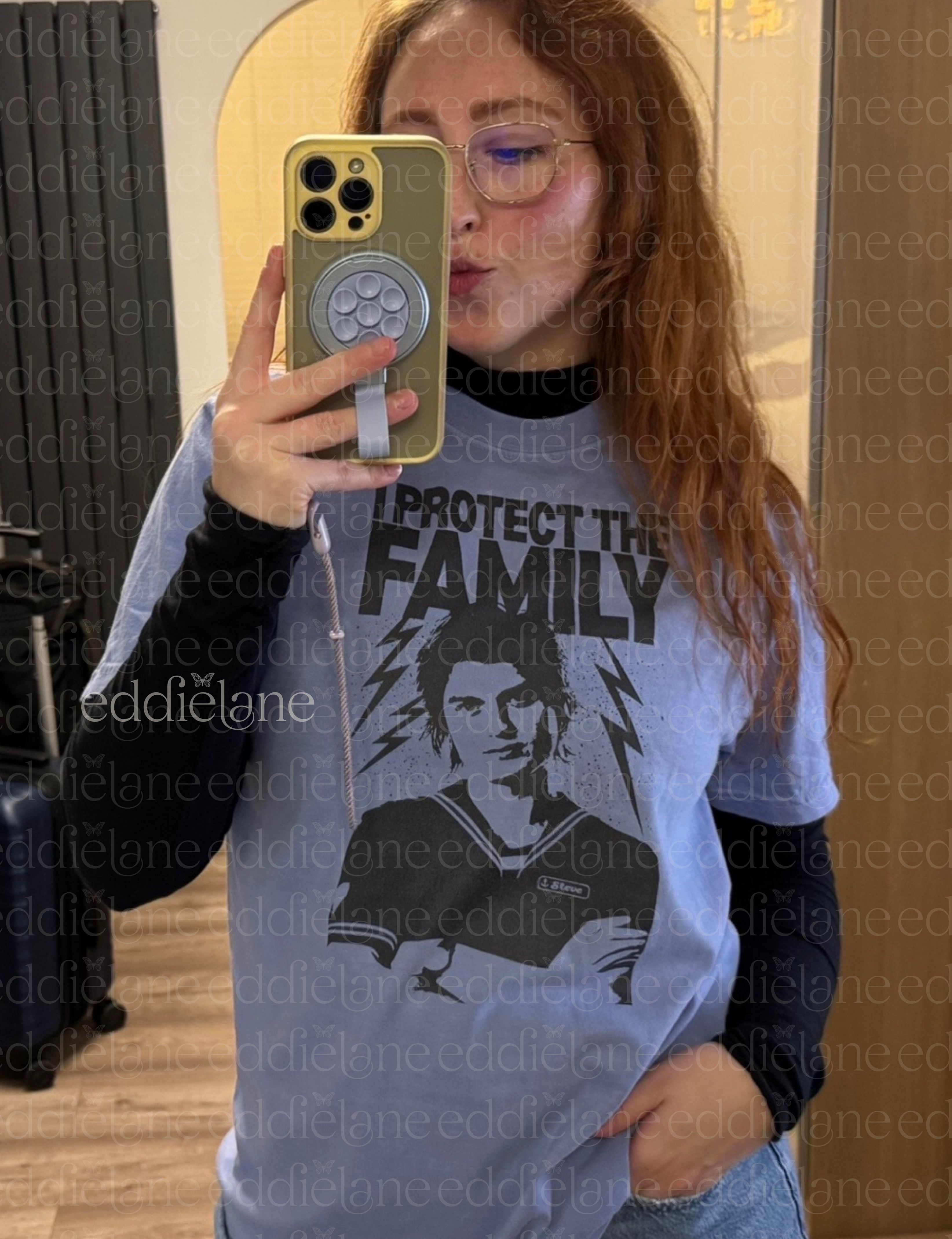 Woman wearing a blue t-shirt with the words "I protect the family" and a graphic of babysitter Steve.