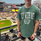 Man wearing a green 'Fly With Me' collegiate t-shirt 