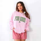 Woman wearing a pink sweatshirt with the text 'FOR GOOD' in a collegiate font.
