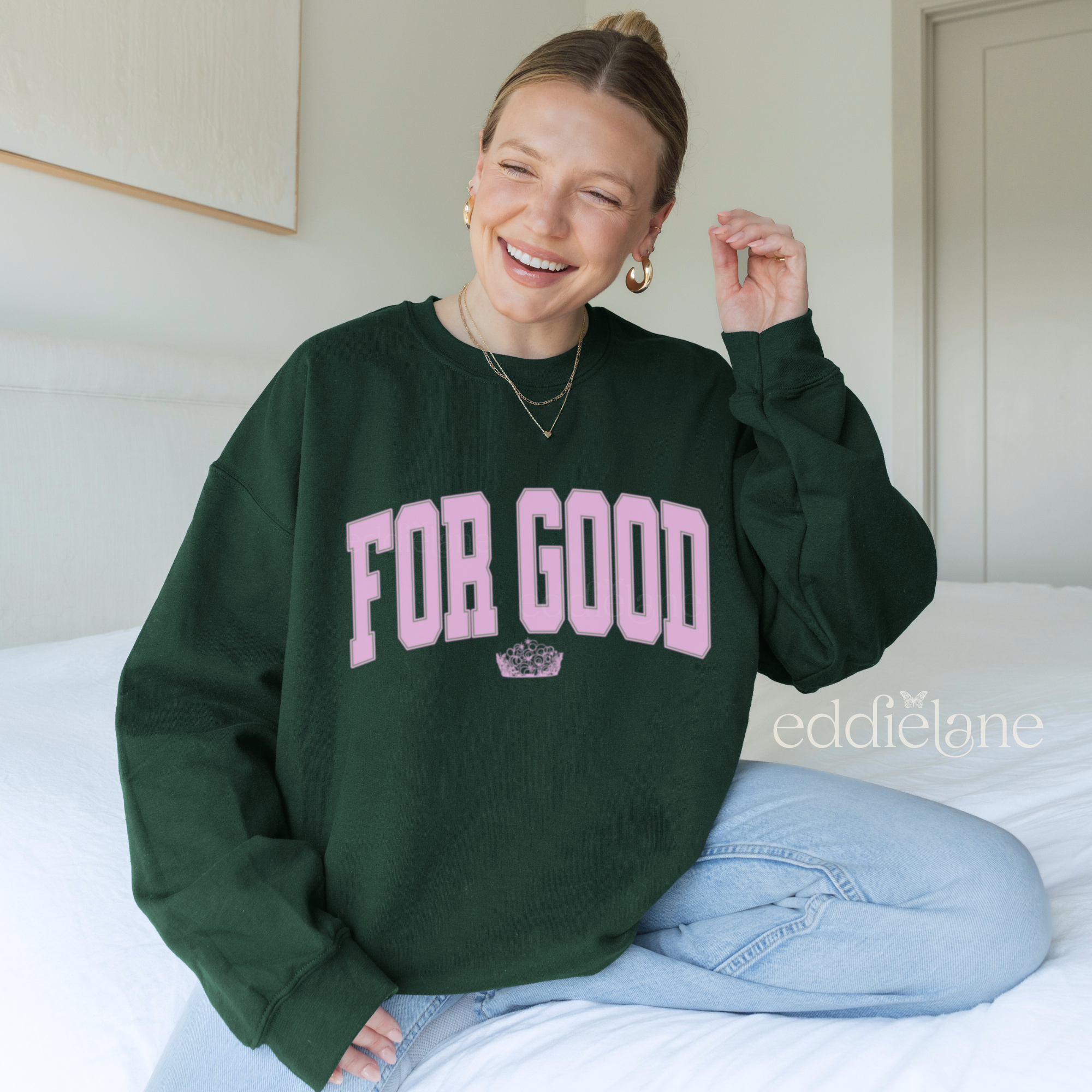 Person wearing a green sweatshirt with 'FOR GOOD' text in a collegiate font.