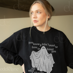Woman wearing a black sweatshirt with a ghost graphic and text, standing against a plain background.