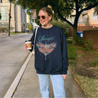 Woman wearing a navy sweatshirt with a graphic design of a woman in a martini glass and the word "showgirl"