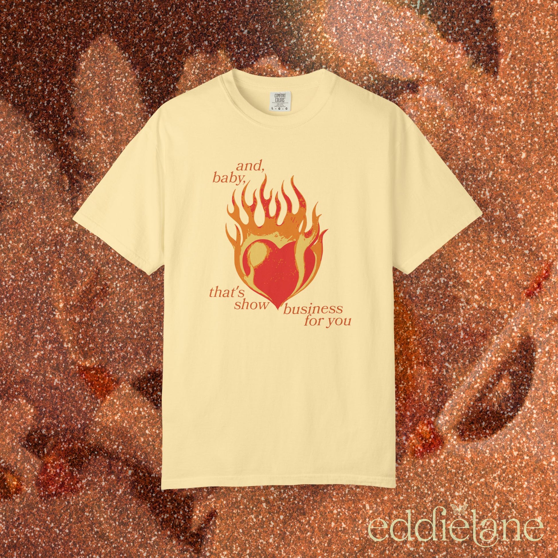 a yellow t-shirt with a heart in flames graphic and the words "and, baby, that's show business for you" inspired by taylor swift.
heart on fire butter