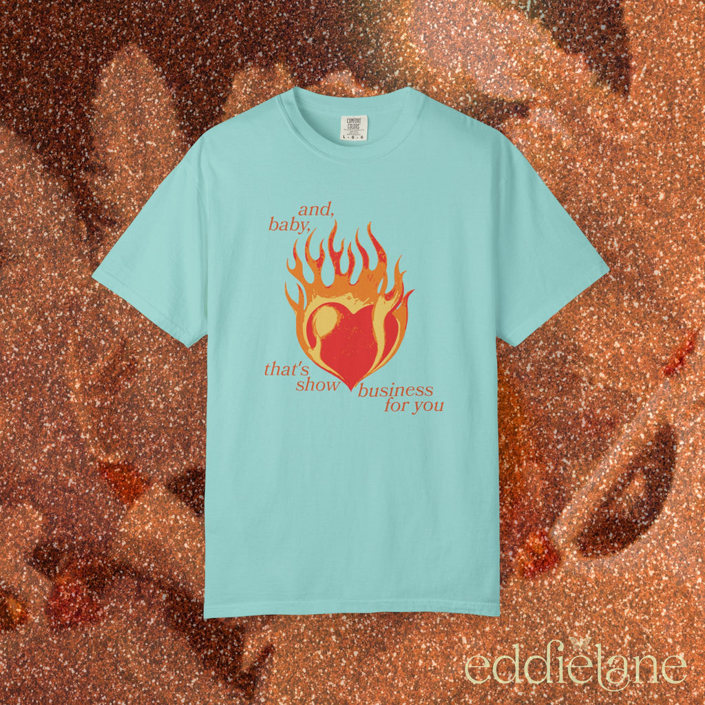 a minty green t-shirt with a heart in flames graphic and the words "and, baby, that's show business for you" 
heart on fire chalky mint