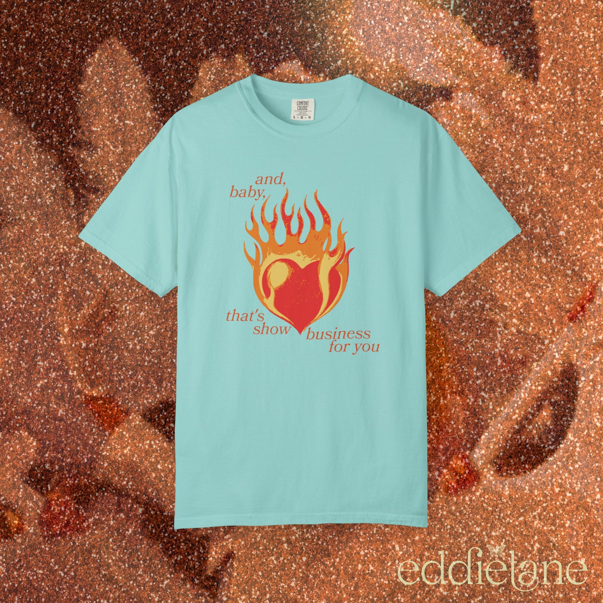 a minty green t-shirt with a heart in flames graphic and the words "and, baby, that's show business for you" inspired by taylor swift.
heart on fire chalky mint