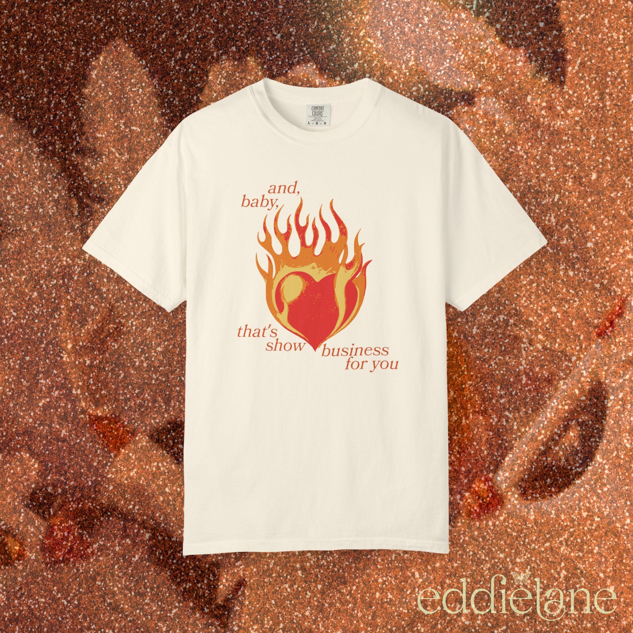 an ivory t-shirt with a heart in flames graphic and the words "and, baby, that's show business for you" 
heart on fire ivory