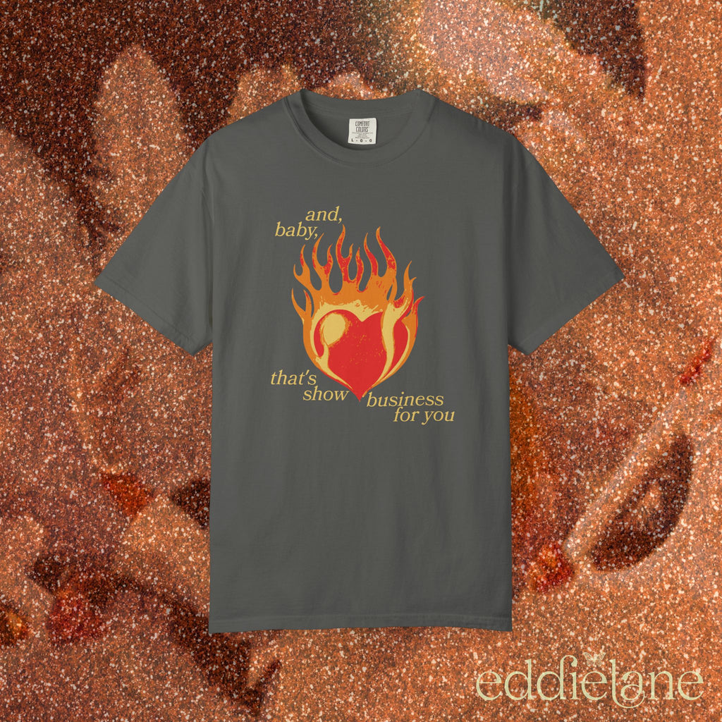 a gray t-shirt with a heart in flames graphic and the words "and, baby, that's show business for you" 
heart on fire pepper