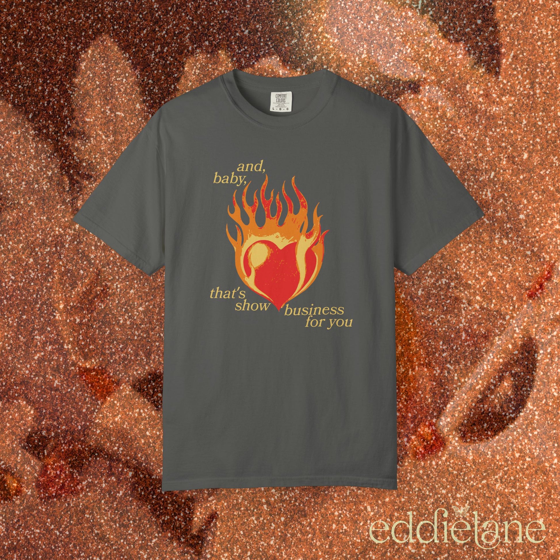 a gray t-shirt with a heart in flames graphic and the words "and, baby, that's show business for you" inspired by taylor swift.
heart on fire pepper