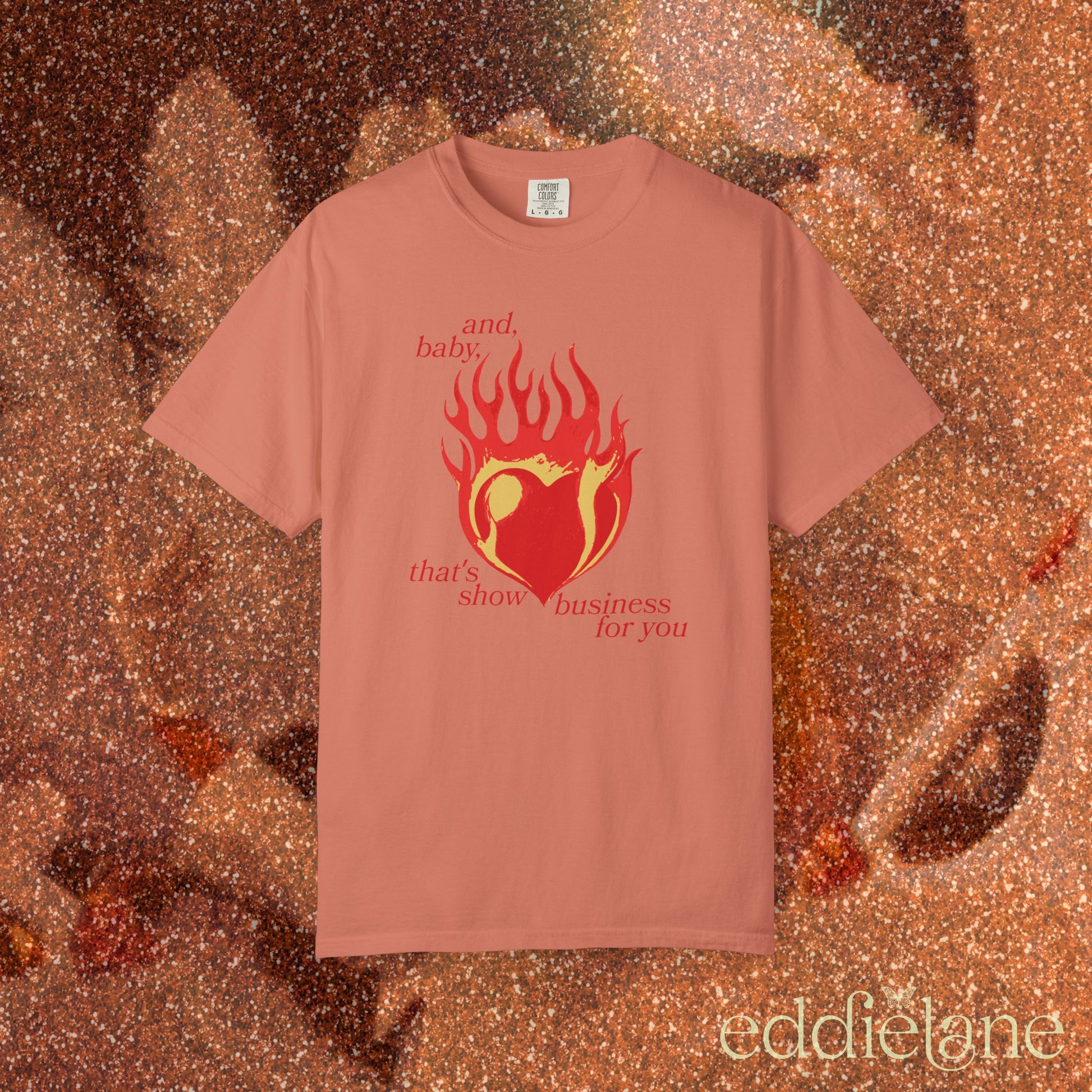 an orange t-shirt with a heart in flames graphic and the words "and, baby, that's show business for you" inspired by taylor swift.
heart on fire terracotta
