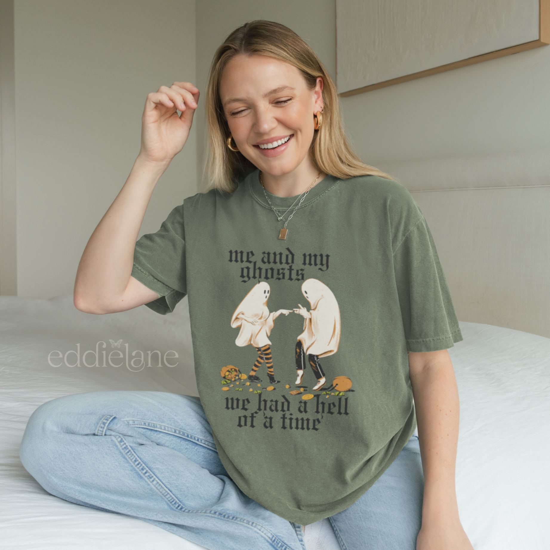 Woman wearing a green halloween graphic tee with a vintage aesthetic, featuring a graphic of two ghosts and the words "me and my ghosts we had a hell of a time"
