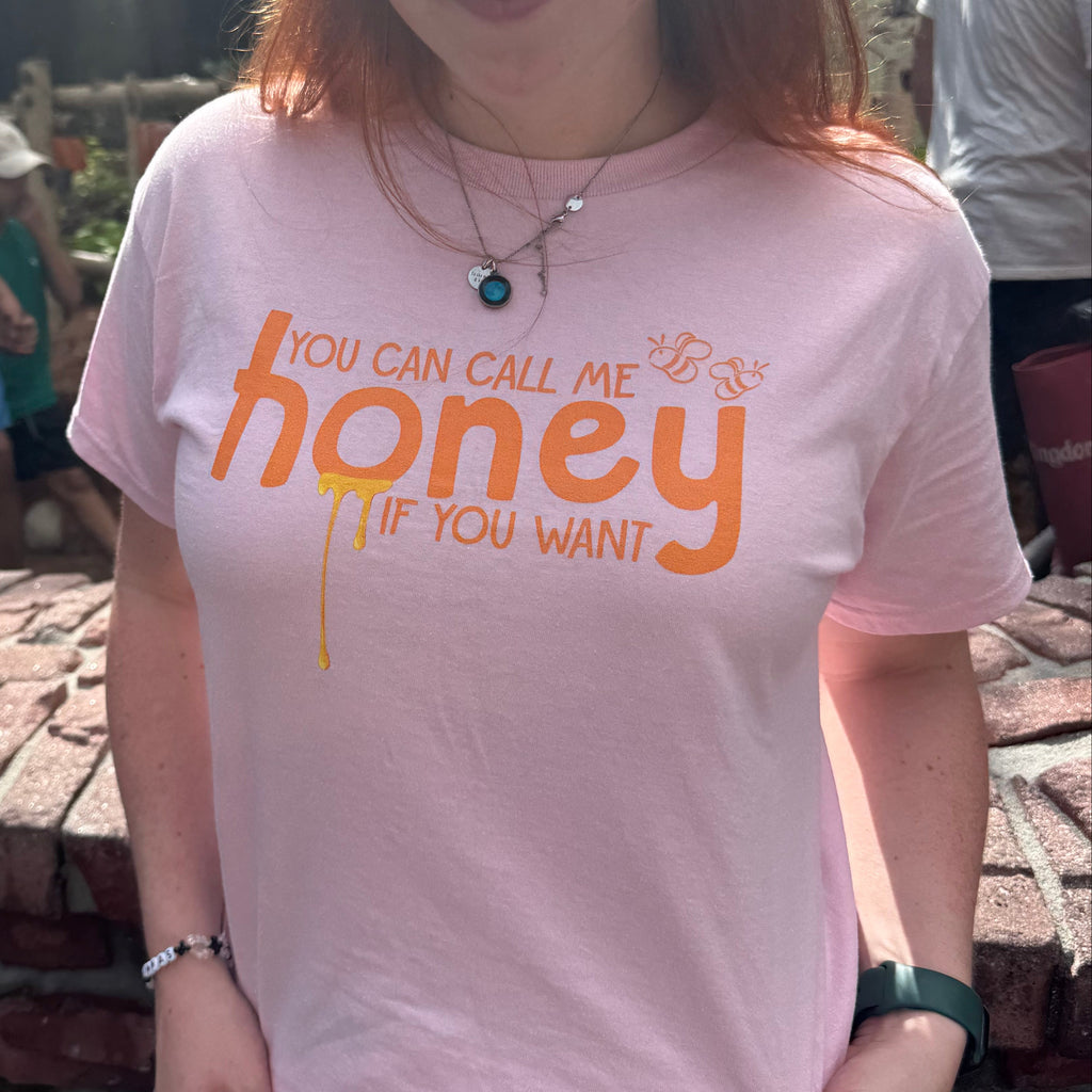 Woman wearing a pink t-shirt with the words "you can call me honey if you want"