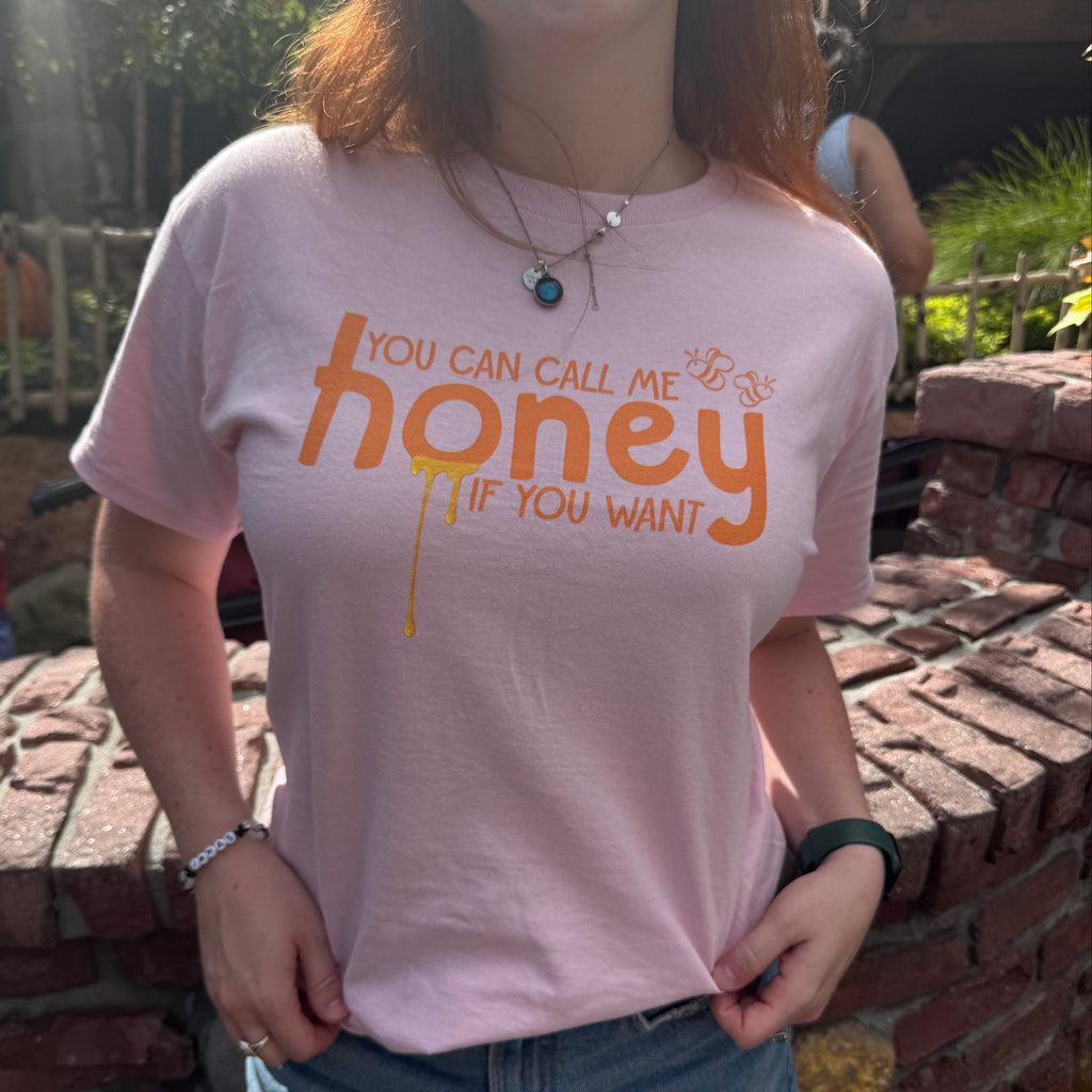 Woman wearing a pink t-shirt with the words "you can call me honey if you want"