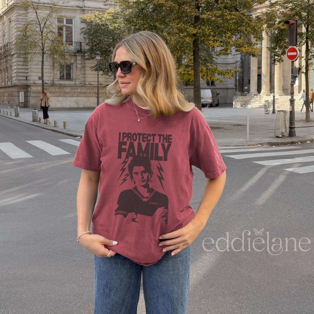 Woman wearing a red t-shirt with the words "I protect the family" and a graphic of a loving babysitter.