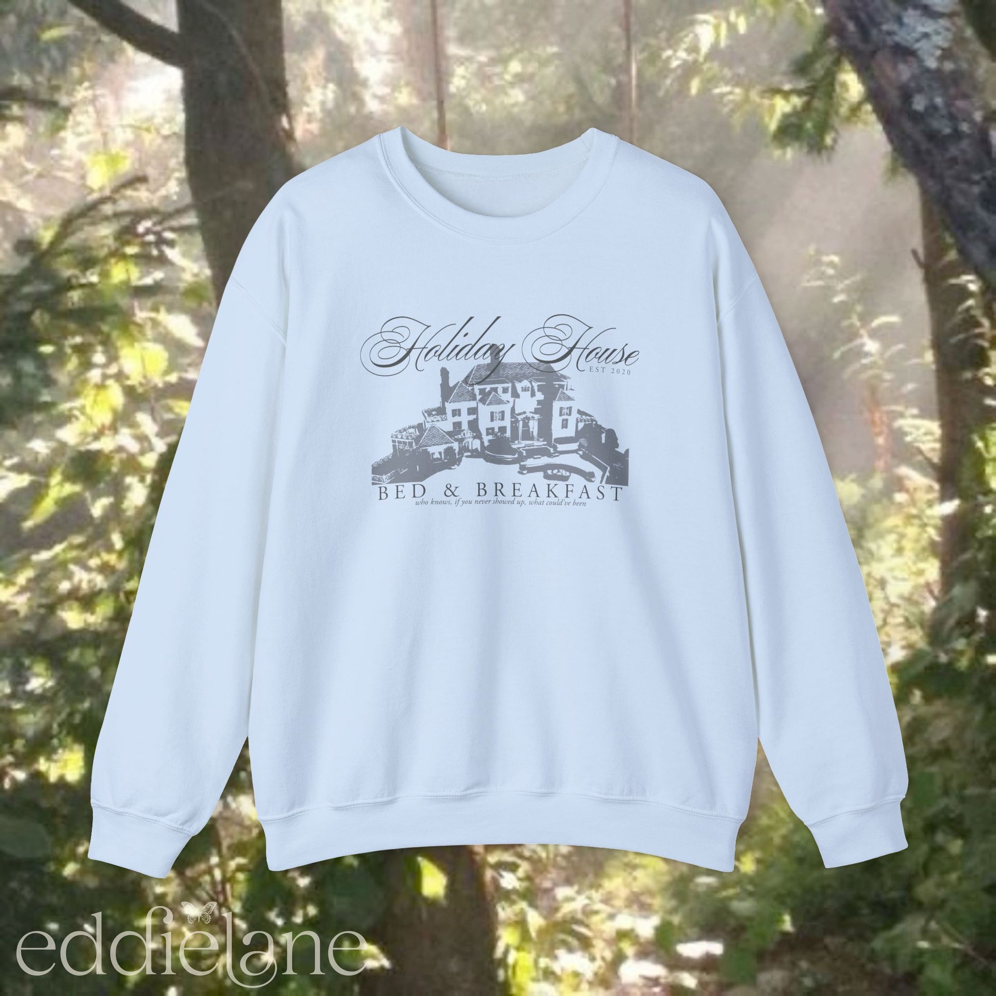 light blue crewneck sweatshirt that says "Holiday House Bed and Breakfast" with a silhouette of the holiday house from taylor swift's the last great american dynasty from folklore.
light blue swiftie sweatshirt holiday house