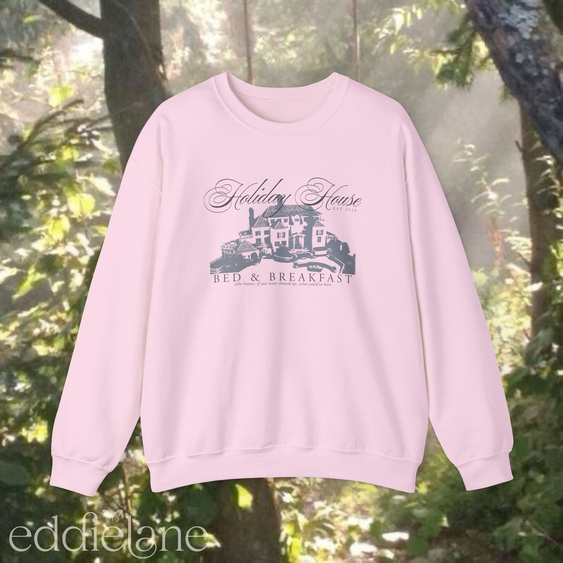 light pink crewneck sweatshirt that says "Holiday House Bed and Breakfast" with a silhouette of the holiday house from taylor swift's the last great american dynasty from folklore.
light pink swiftie sweatshirt holiday house