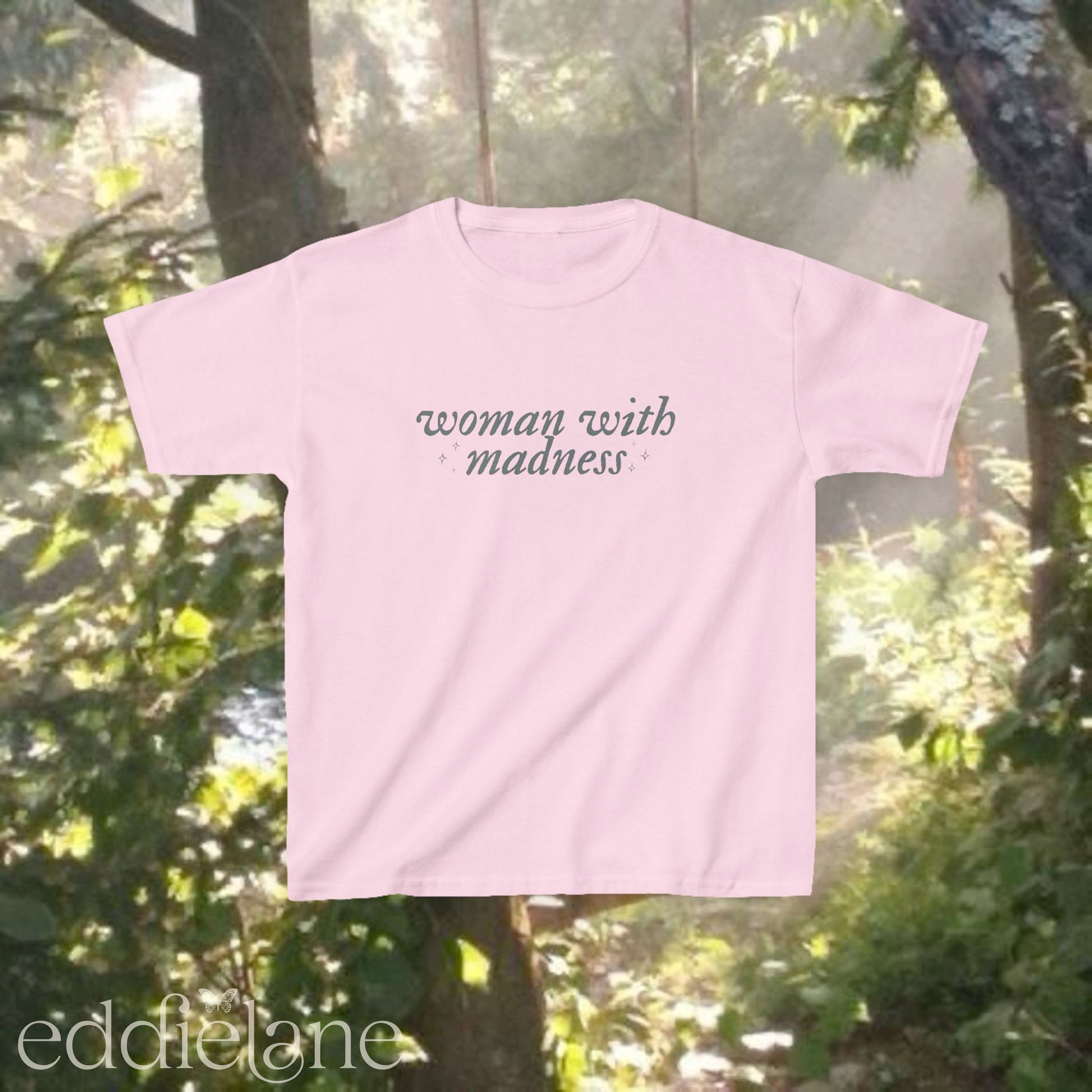 Light pink baby tee with words "woman with madness" inspired by the last great american dynasty from folklore by taylor swift.
