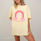 Woman wearing a yellow graphic t-shirt with a rainbow design and text that says "ooh wee I love the jonas brothers" 