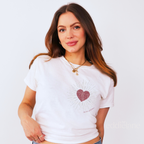 Woman wearing a white baby tee with a heart design inspired by the dress from the fate of ophelia