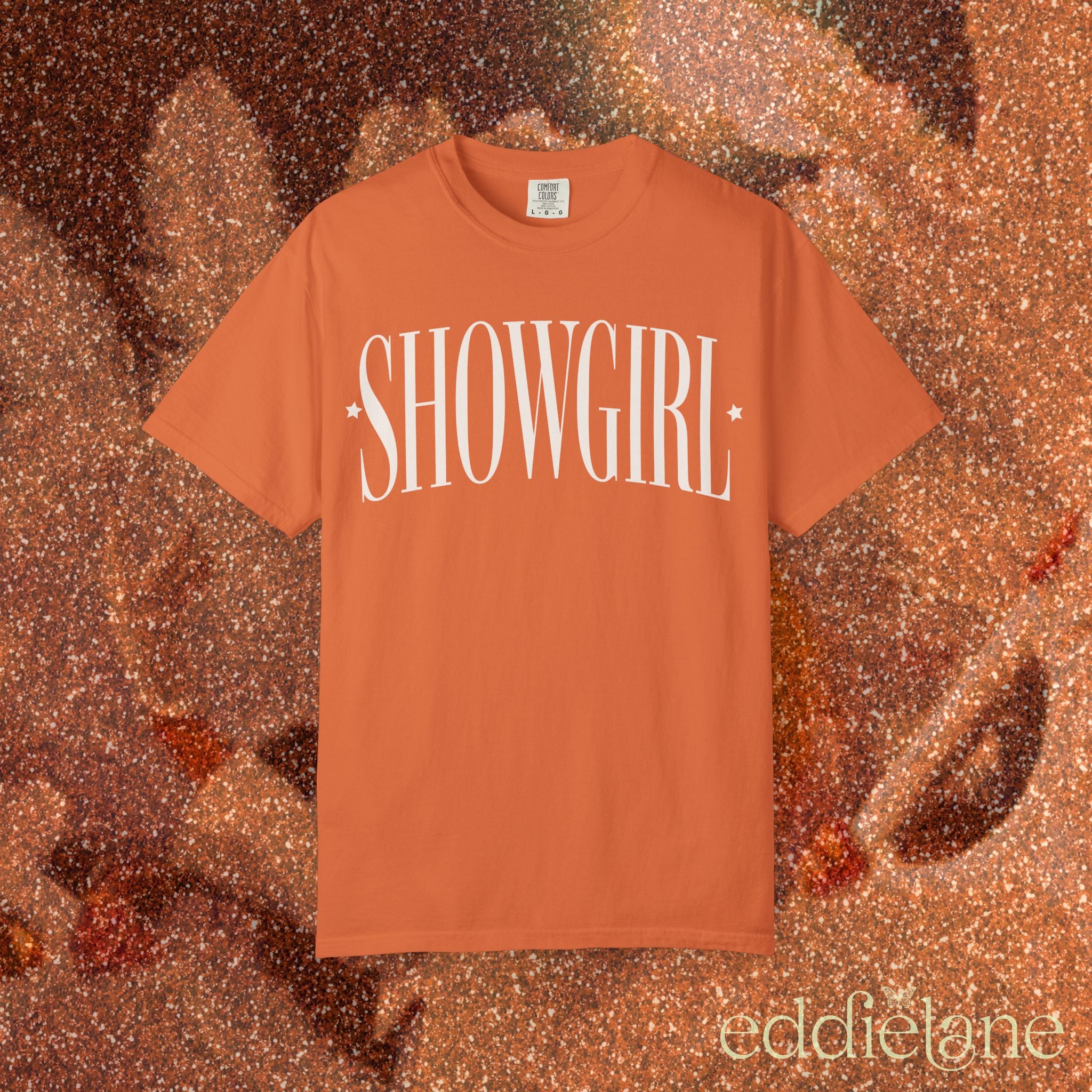 an orange comfort colors graphic tee that says 'SHOWGIRL' with two small stars 

orange showgirl title tee