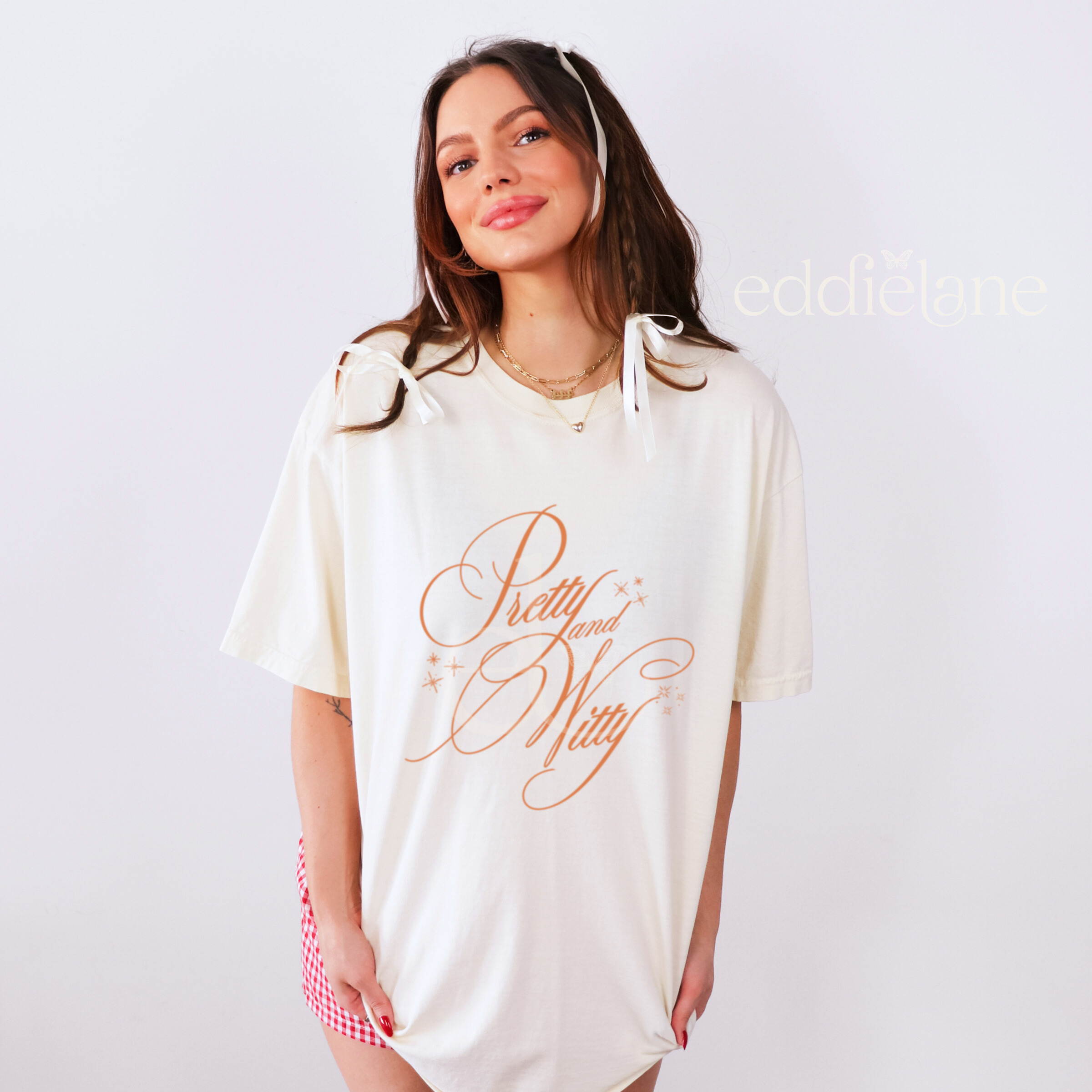 Woman wearing an ivory oversized t-shirt with the words "pretty and witty" 