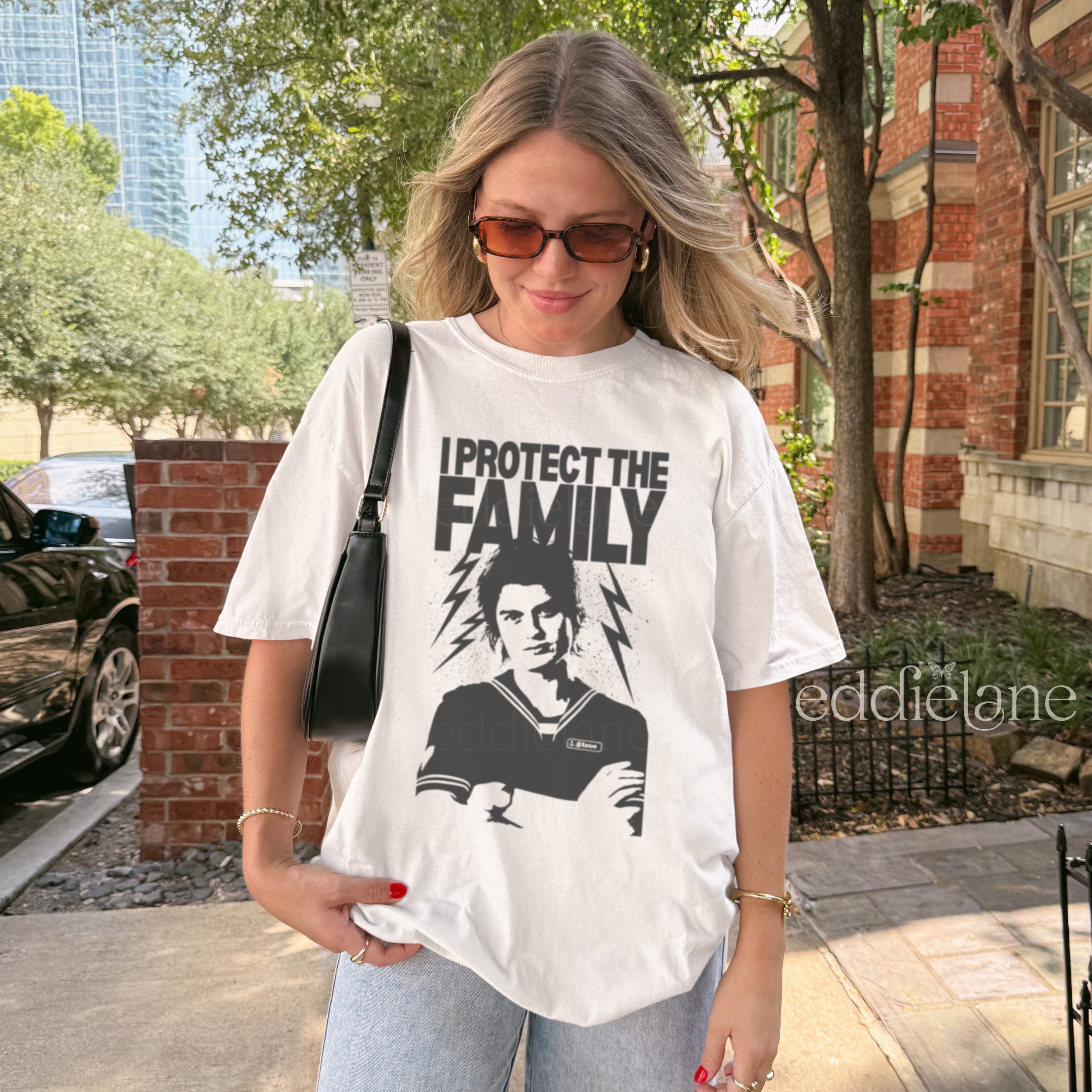 Woman wearing a white t-shirt with the words "I protect the family" and a graphic of a loving babysitter.