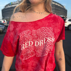 Woman wearing a red tie-dye shirt that says "red dress" in curvy lettering
