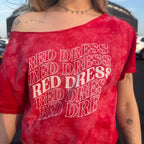 Woman wearing a red tie-dye shirt that says "red dress" in curvy lettering 