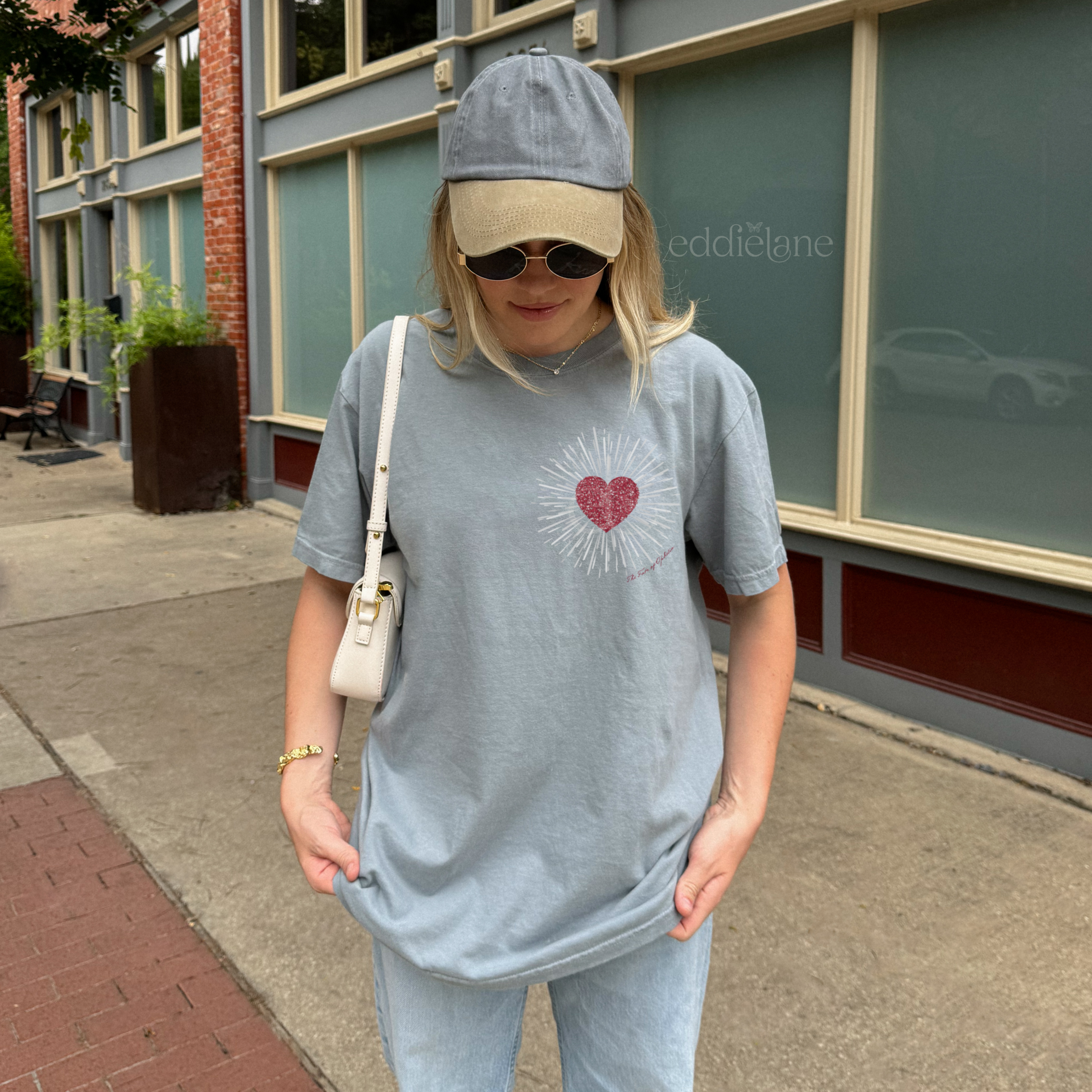 woman wearing a gray comfort colors tshirt with a red heart design inspired by the fate of ophelia