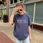 Woman wearing a navy comfort colors t-shirt that says 'Sundays are for Taylor' 