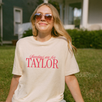 Woman wearing an ivory comfort colors t-shirt that says 'Sundays are for Taylor' 